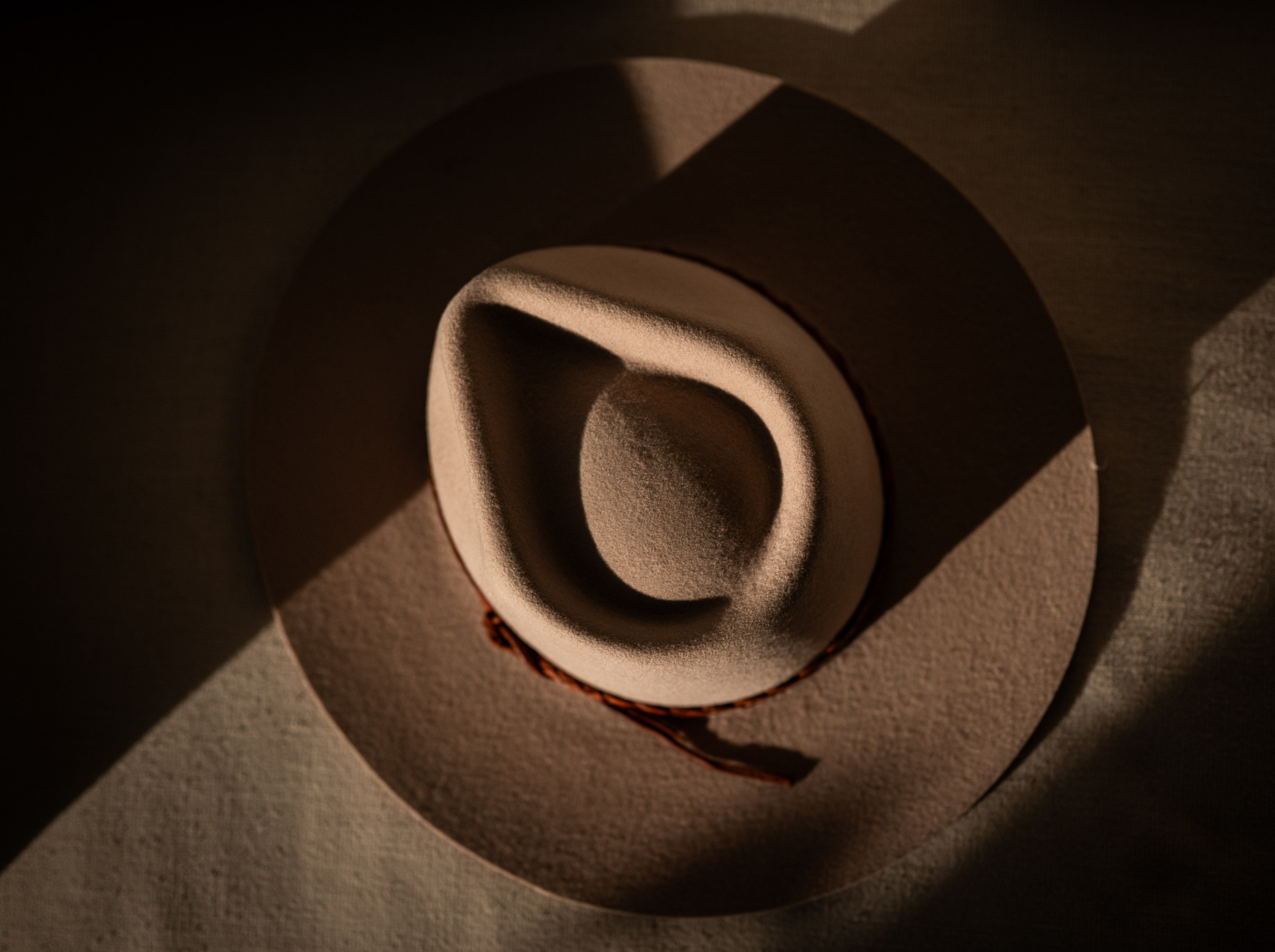 Le Souk bone hat seen from above, teardrop crease and braided leather band visible.