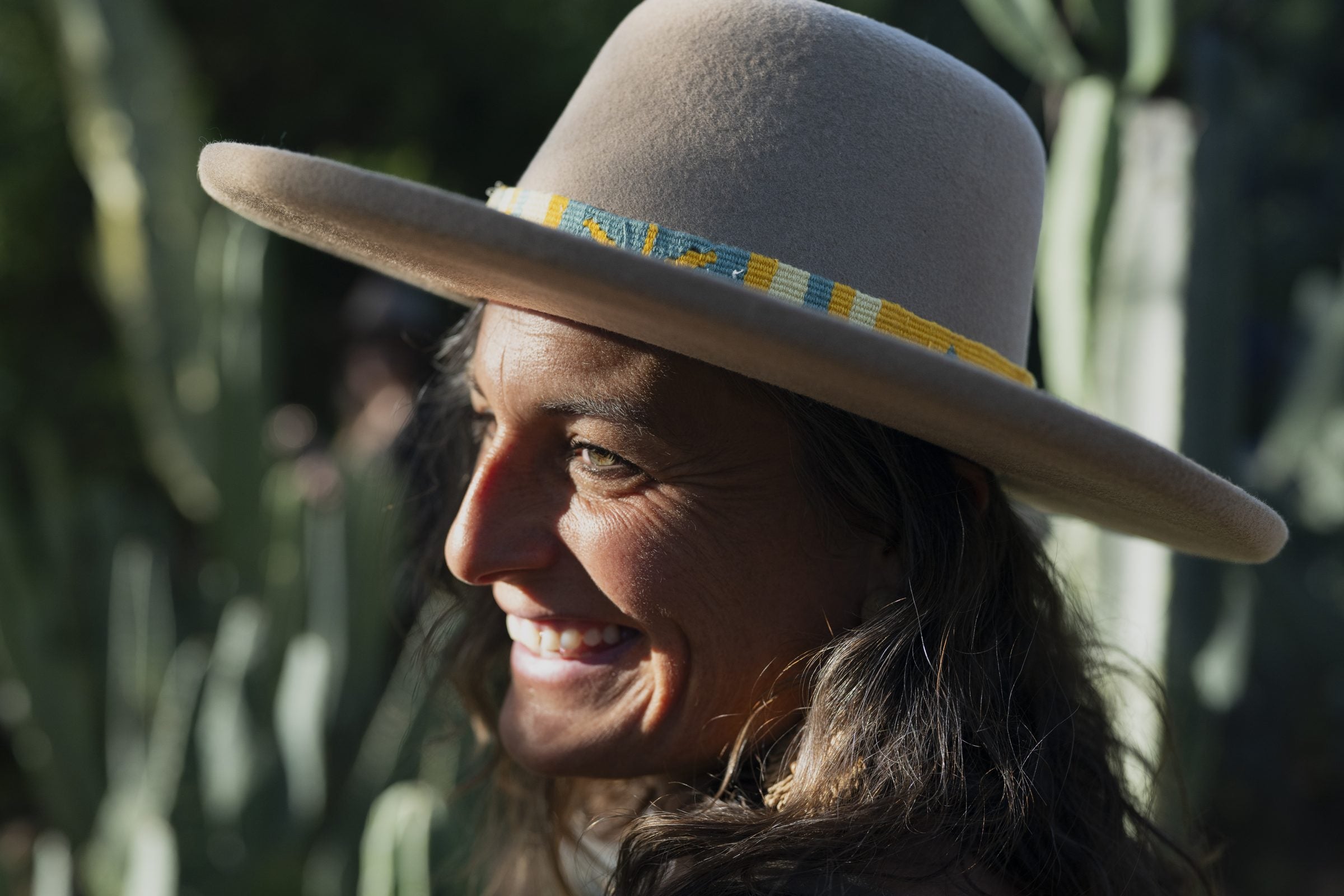 Sonora Daybreak camel open crown hat on model among Sonoran cacti at golden hour, hand-woven band visible.